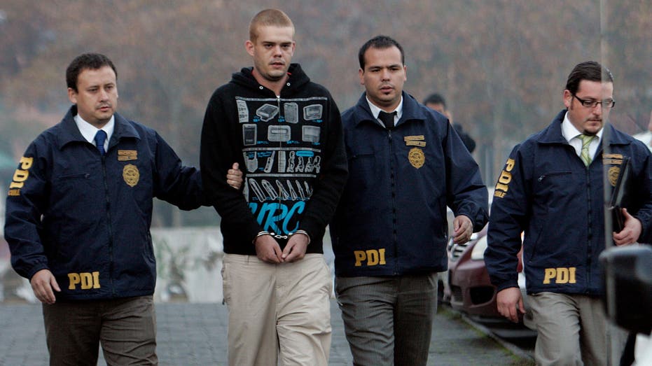 Joran Van der Sloot is escorted by police officers to the airport in Santiago